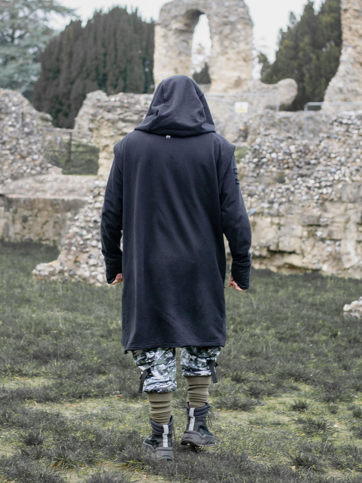 Arakion Mens Asymmetric Zip Up Hoodie with Thumbholes and Distressed Details in Black - image of the back in motion as the model is walking away