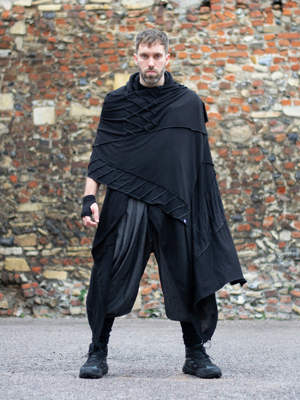 Oversized black bamboo scarf with overlock stitching, styled as a draped wrap. Futuristic and flowy, with a post-apocalyptic edge. Breathable, lightweight, and versatile for layered looks.