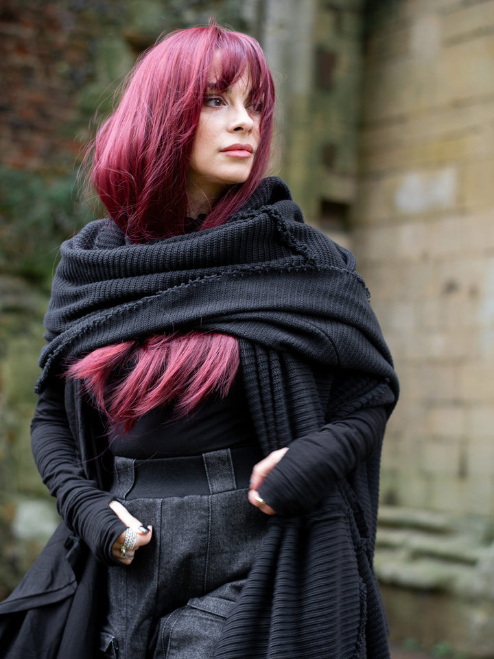 Athos - an avant garde oversized scarf in a premium chain knit material, with abstract panels and overlock stitch details for a raw alternative look. Paired with combat boots and cargo pants.