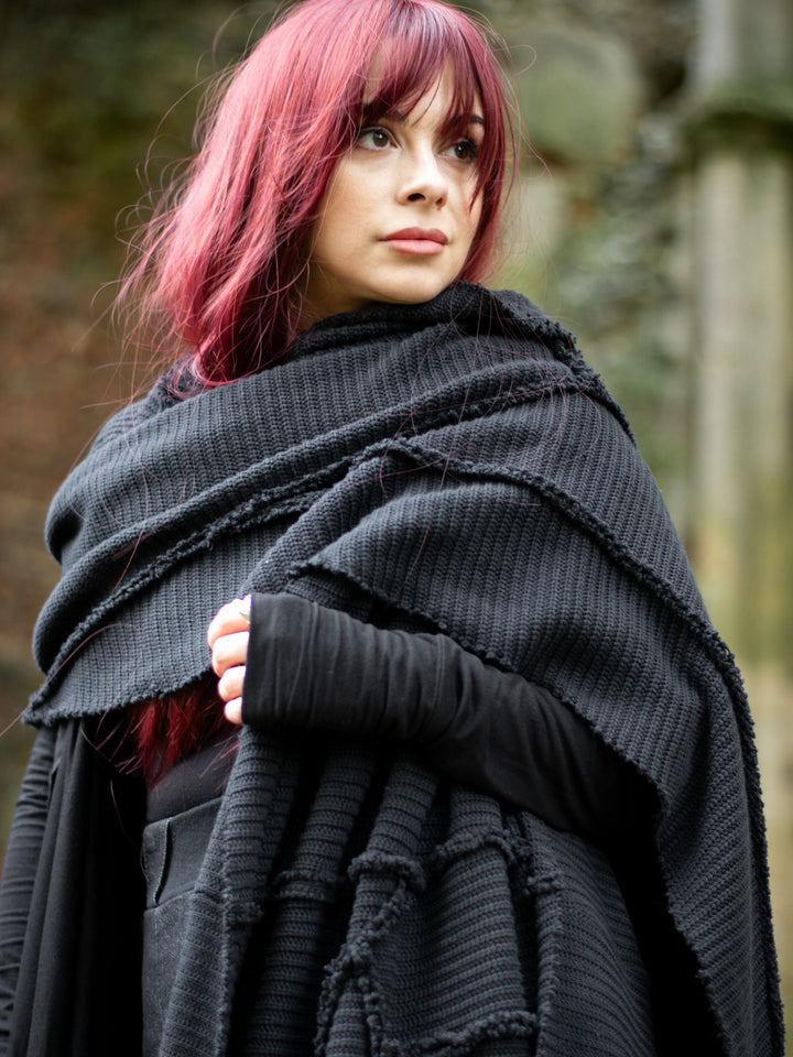 Athos - an avant garde oversized scarf in a premium chain knit material, with abstract panels and overlock stitch details for a raw alternative look. Paired with combat boots and cargo pants.