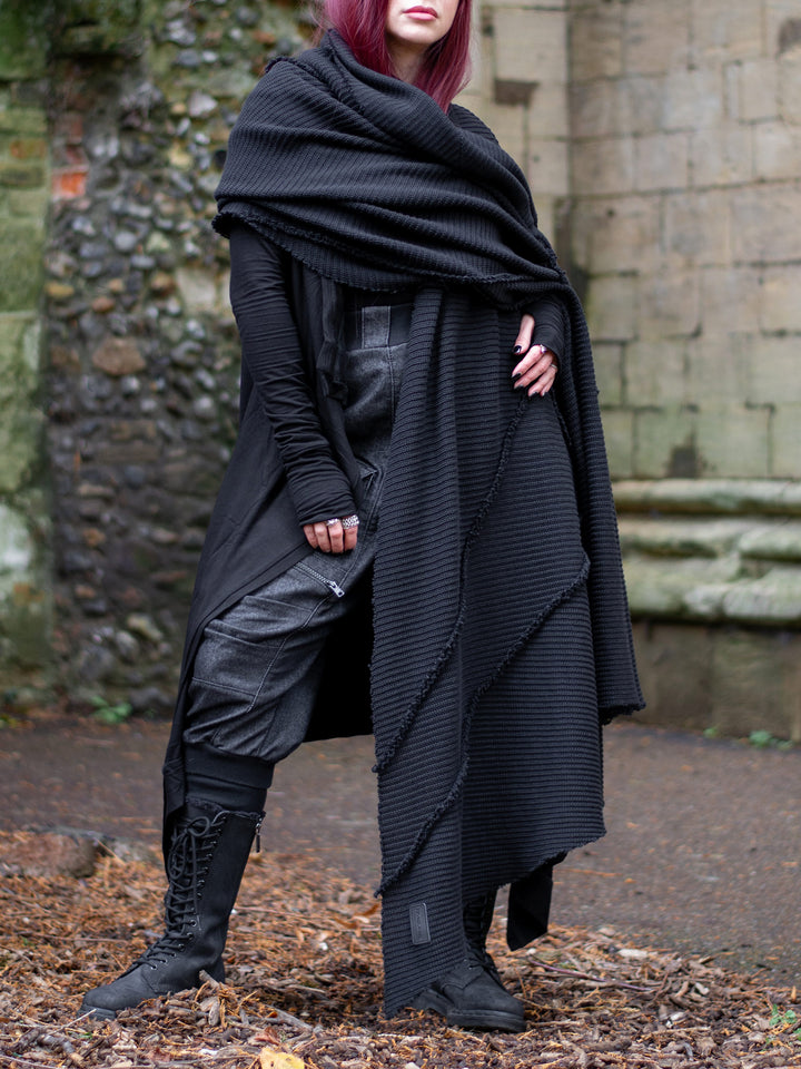 Athos - an avant garde oversized scarf in a premium chain knit material, with abstract panels and overlock stitch details for a raw alternative look. Paired with combat boots and cargo pants.
