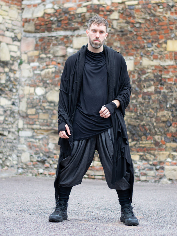 Wide-leg drop crotch ninja harem pants with voluminous pleats and tapered calf supports. Avant garde flowy mens trousers for performers, festivals or interesting looks. Combined with a draped black t-shirt and oversized scarf. 