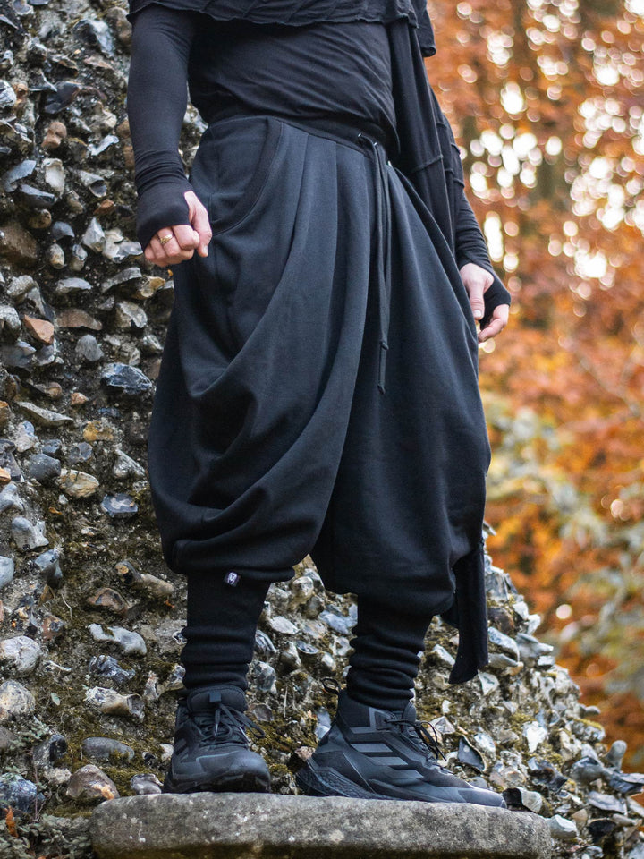 Hattori Avant Garde Ninja Pants with Drop Crotch, Japanese Style Trousers in Black - image showing the ninja pants worn outdoors in a Japanese garden by a ninja