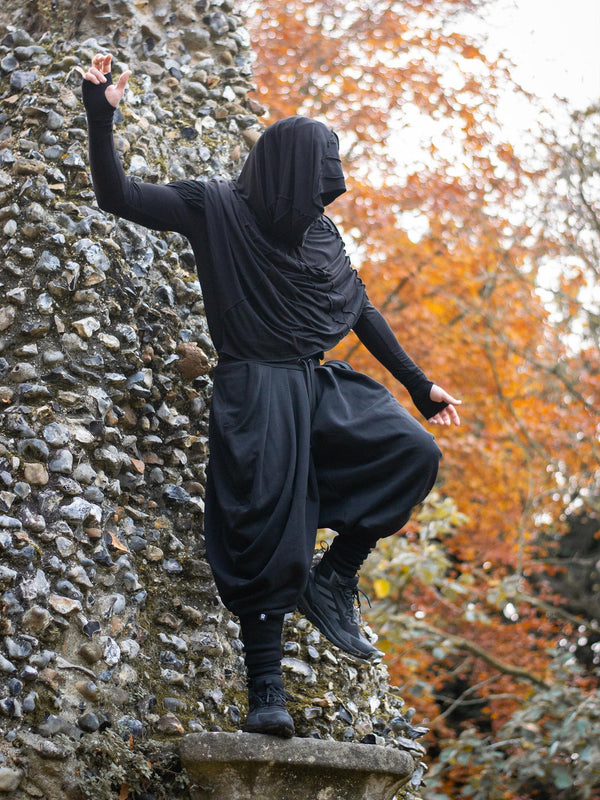 Hattori Avant Garde Ninja Pants with Drop Crotch, Japanese Style Trousers in Black - image showing the ninja pants worn outdoors in a Japanese garden by a ninja