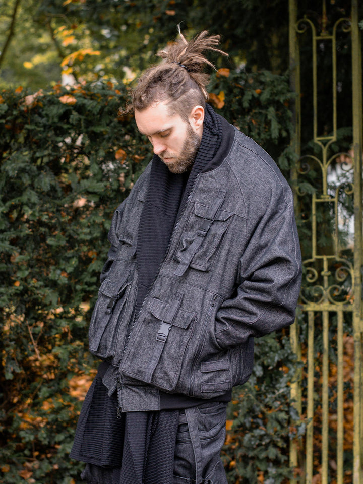 Kronos Men's Oversized Bomber Jacket with 10 Pocket Design, Metal Buckles and Thumbholes - Angled view with jacket open and hands in the pockets