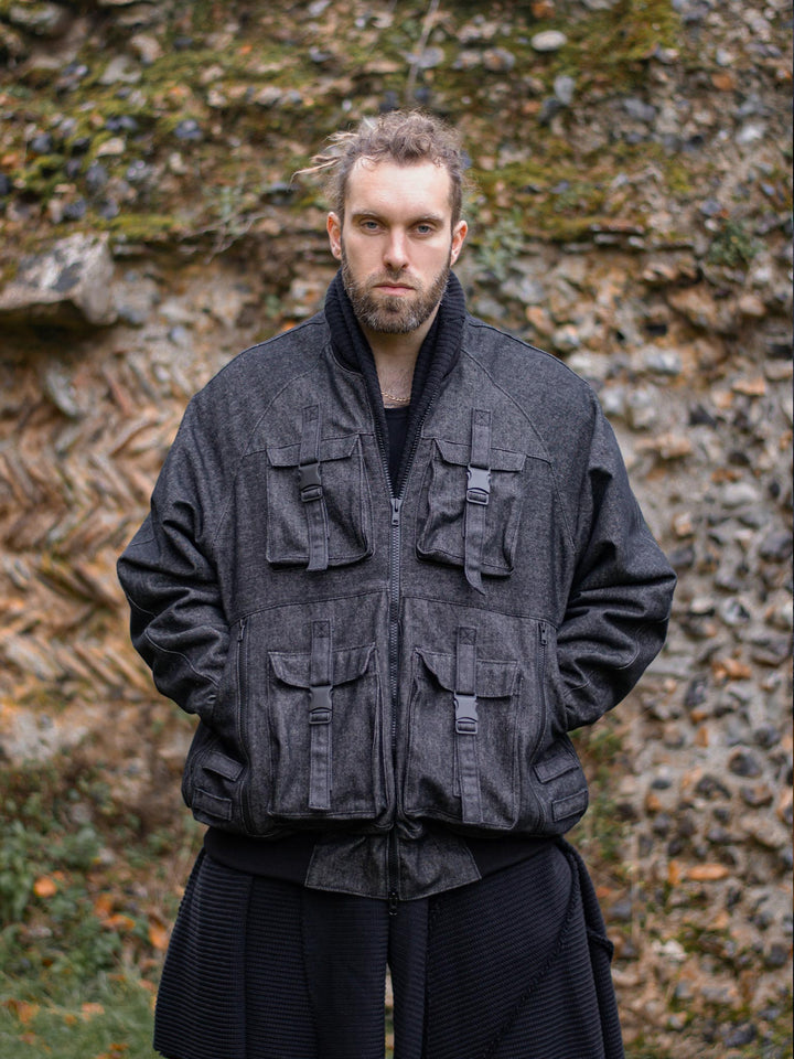 Kronos Men's Oversized Bomber Jacket with 10 Pocket Design, Metal Buckles and Thumbholes - Front view with the jacket closed and hand in the pockets