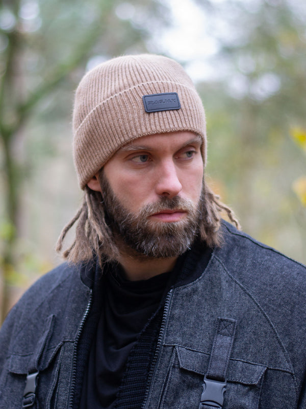 Close-up of a ribbed knit Merino wool beanie in camel beige, featuring a turn-up cuff and a RagJak leather tag on the fold-up. A versatile and stylish winter accessory designed for warmth and durability.