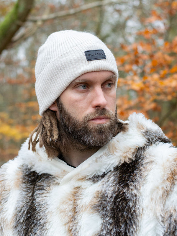 Close-up of a ribbed knit Merino wool beanie in cream, featuring a turn-up cuff and a RagJak leather tag on the fold-up. A versatile and stylish winter accessory designed for warmth and durability.