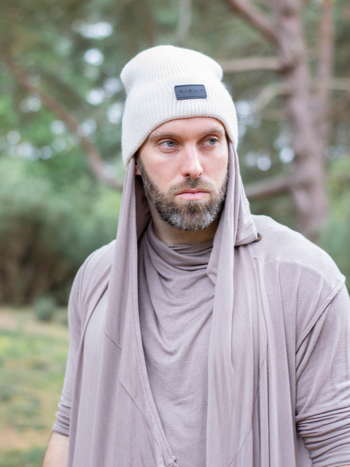 Close-up of a ribbed knit Merino wool beanie in cream, featuring a turn-up cuff and a RagJak leather tag on the fold-up. A versatile and stylish winter accessory designed for warmth and durability.