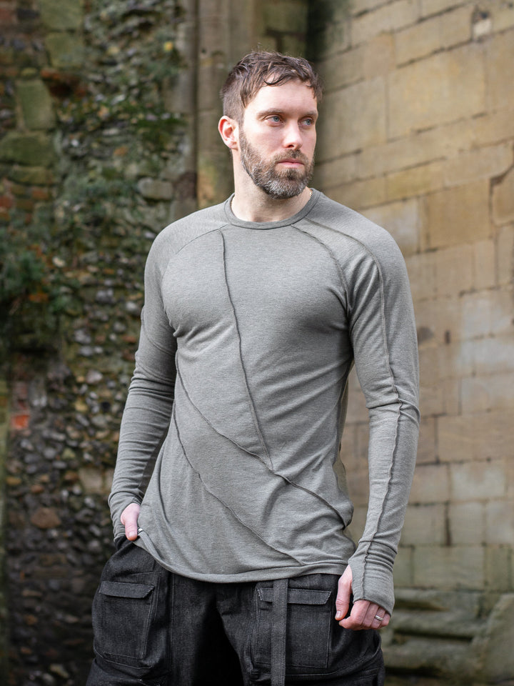 Men’s avant garde long sleeve top in Moss Grey with abstract overlock stitching, raglan sleeves, thumbholes, and longline slim silhouette. Bamboo jersey base layer - Angle Image