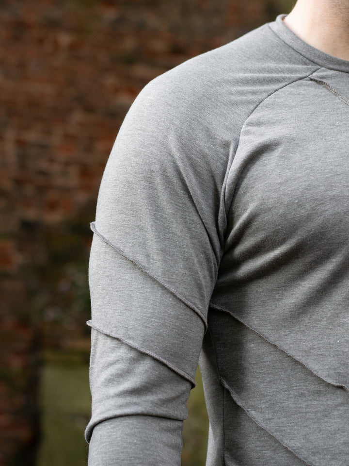 Men’s avant garde long sleeve top in Moss Grey with abstract overlock stitching, raglan sleeves, thumbholes, and longline slim silhouette. Bamboo jersey base layer - Shoulder Detail