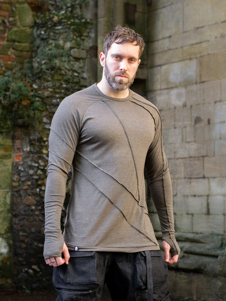 Men’s avant garde long sleeve top in Dark Taupe with abstract overlock stitching, raglan sleeves, thumbholes, and longline slim silhouette. Bamboo jersey base layer styled with techwear cargos. - Front Image