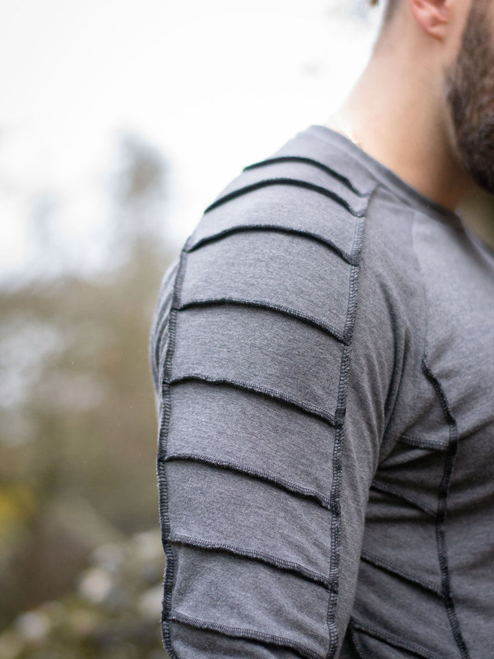 Raider Men's Longline T-Shirt with Thumbholes in Charcoal Grey, with Overlock Contrast Stitch in Black - close up of the raglan sleeve and overlock stitch details on the shoulder and sleeve