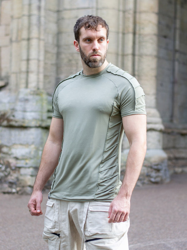 Men’s sage short sleeve t-shirt with raglan sleeves and distressed overlock details, crafted from breathable bamboo jersey. Slightly sculpted fit with a dystopian, avant-garde aesthetic—ideal for festivals, raves, or alternative summer styling.