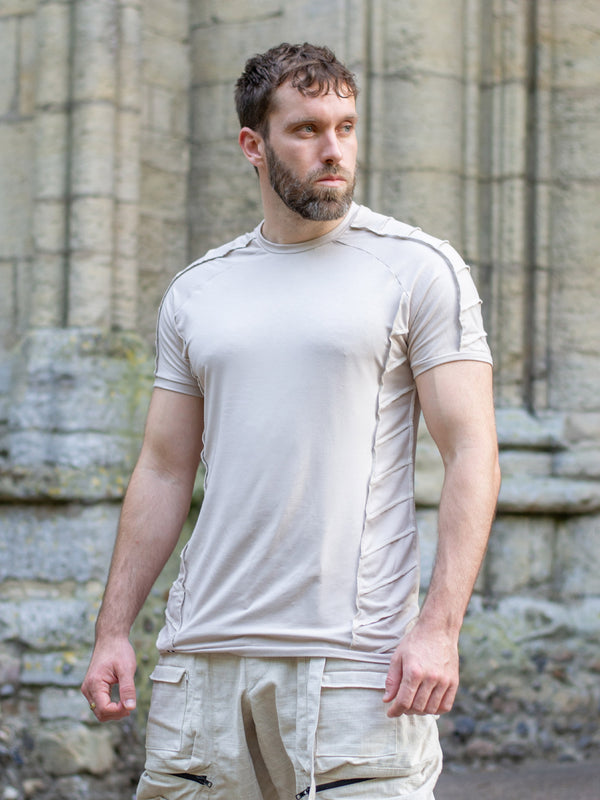 Men’s sand short sleeve t-shirt with raglan sleeves and distressed overlock details, crafted from breathable bamboo jersey. Slightly sculpted fit with a dystopian, avant-garde aesthetic—ideal for festivals, raves, or alternative summer styling.