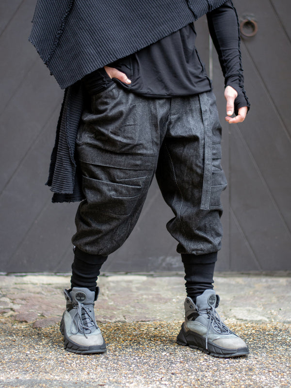 Model wearing Rhidian Cargos — designer drop crotch cargo pants in heavyweight black denim with 4-pocket design and metal hardware.