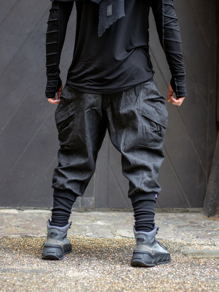 Back view of men's denim cargo pants with relaxed drop crotch, ribbed waistband and 4 pocket design. 