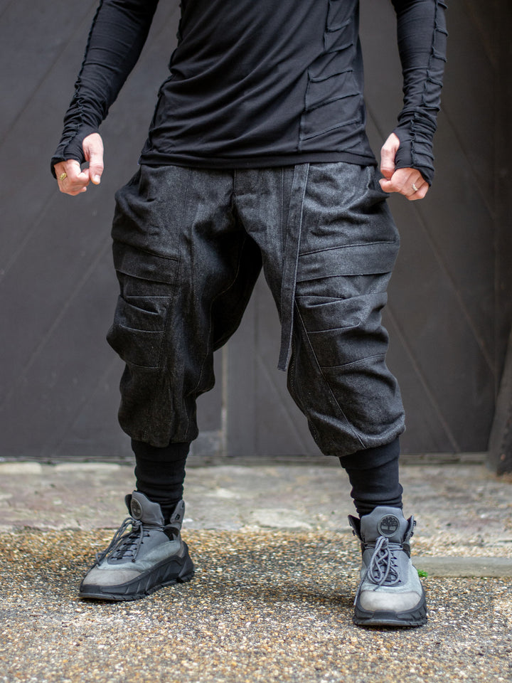 Model wearing Rhidian Cargos — designer avant garde drop crotch cargo pants in heavyweight denim with 4-pocket design and metal hardware.