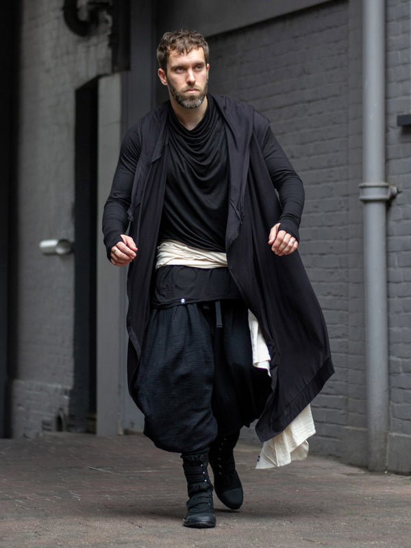 Men’s longline black cloak with oversized hood and asymmetric closure in soft bamboo jersey — avant-garde dystopian layering piece with fluid drape and shadow-inspired design.