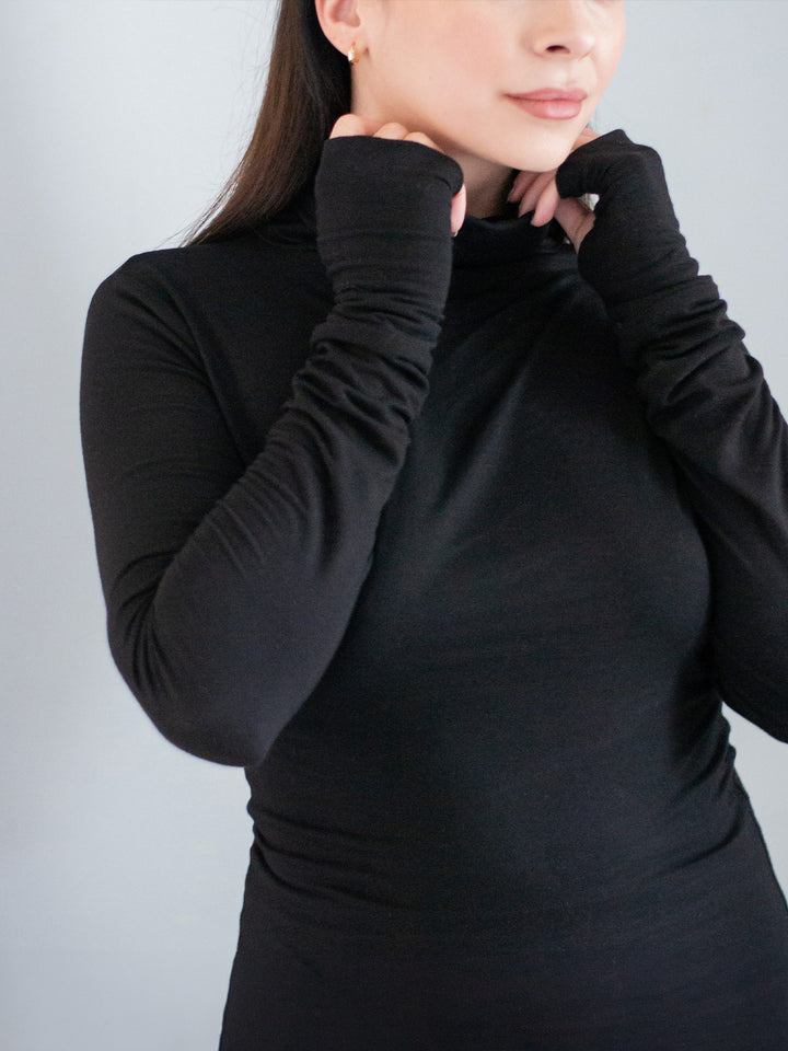 Xina Women's Roll Neck T-shirt with Thumboles in Black. A slimline silhouette with long sleeves and functional thumbholes for both casual and active styles. Close Up of the sleeve