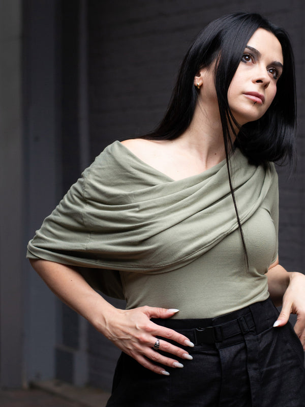 Model wearing Yara sage green short sleeve hooded t-shirt in bamboo jersey, with soft drape, double-layer hood, and fitted silhouette — alternative designer streetwear by Rags by Jak.