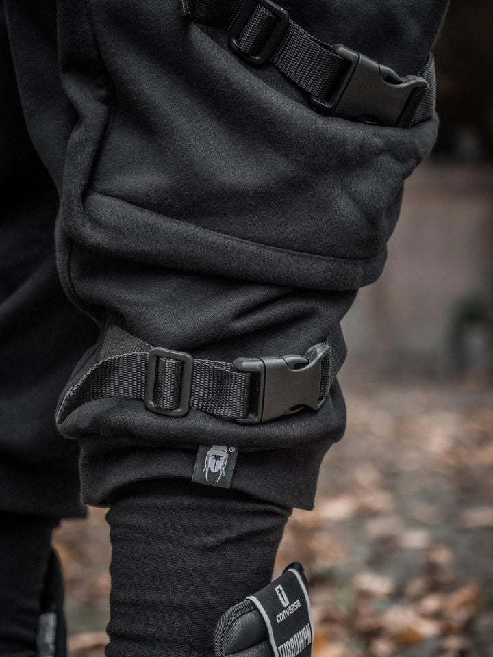 Zye Men's Drop Crotch Joggers in Black, featuring Straps and Buckles, and a functional 4 pockets design - close up of the details and logo