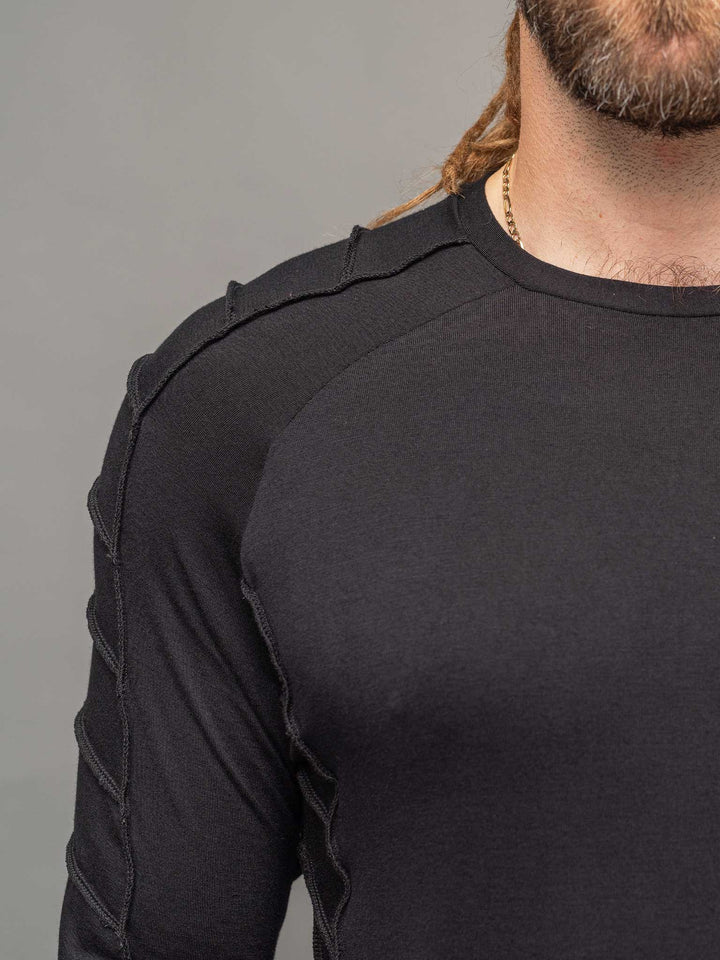 Raider dystopian men's longline tshirt with thumboles and overlock stitch details in black - focus on shoulder area