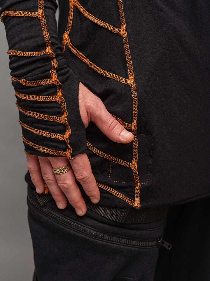 Raider dystopian avant garde men's longline tshirt in black with thumbholes and overlock contrast stitch in orange - focus on thumbholes