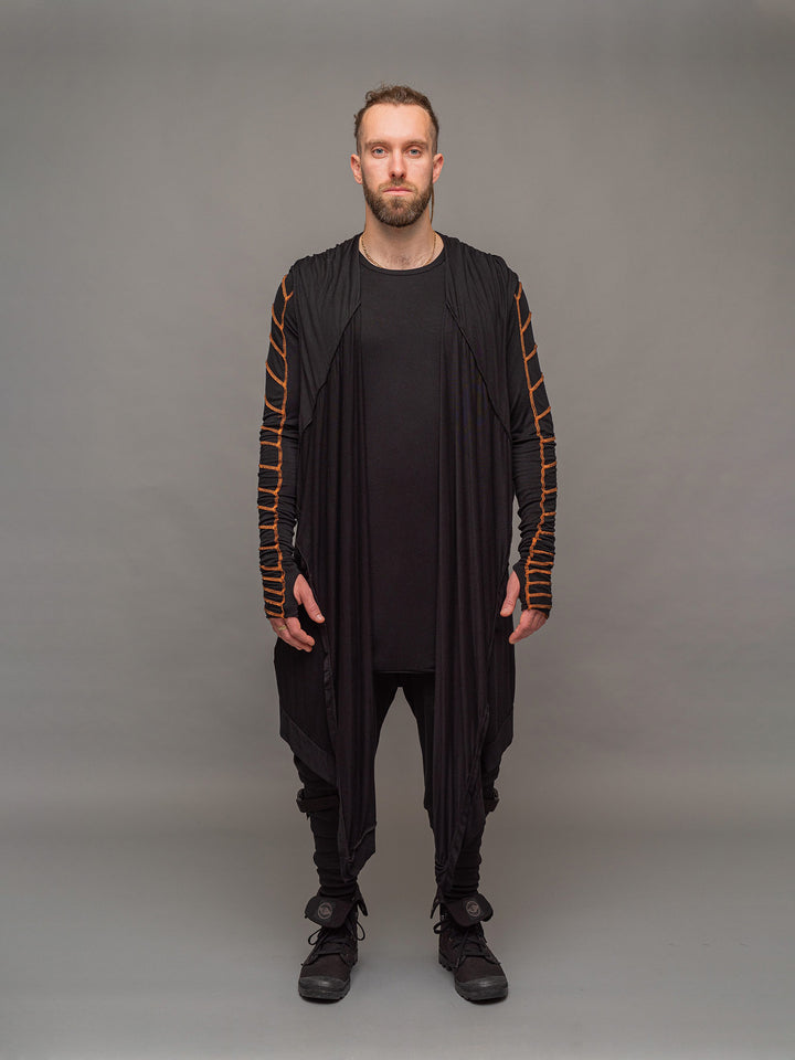 Raider dystopian avant garde men's longline tshirt in black with thumbholes and overlock contrast stitch in orange - full body view styled with the Shadow cloak in black