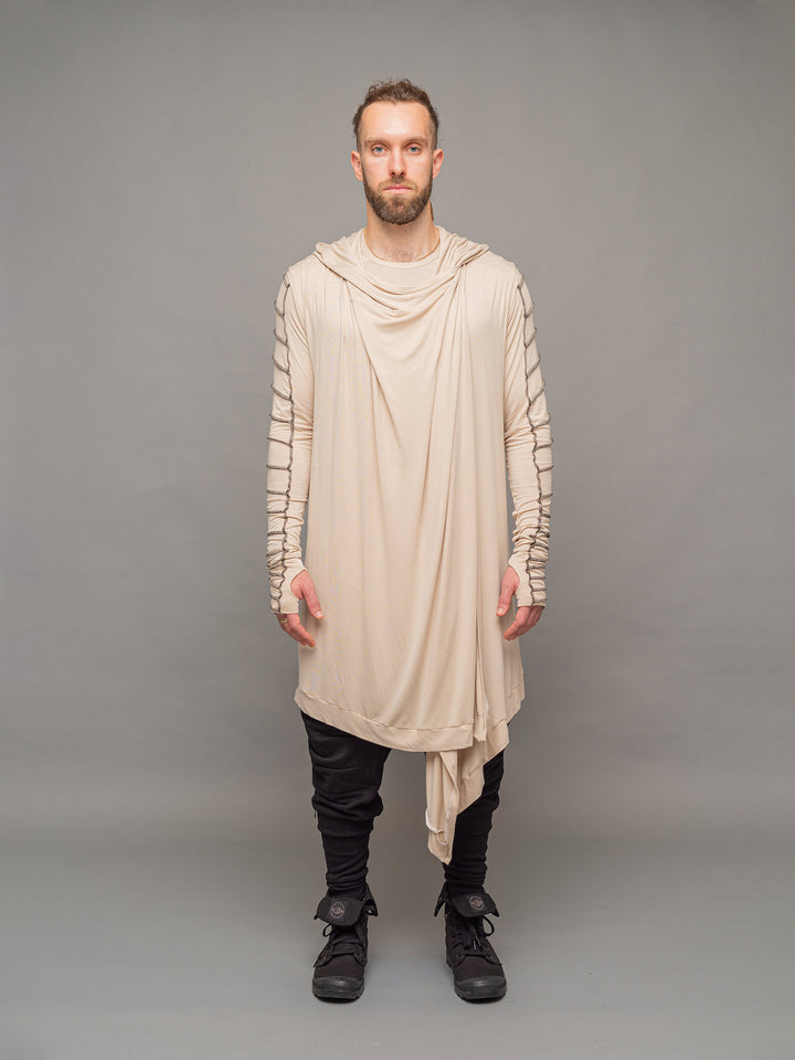Raider dystopian avant garde men's longline t-shirt in sand with black contrast stitch and thumbholes for a distressed look - full body view styled with Shadow cloak in sand