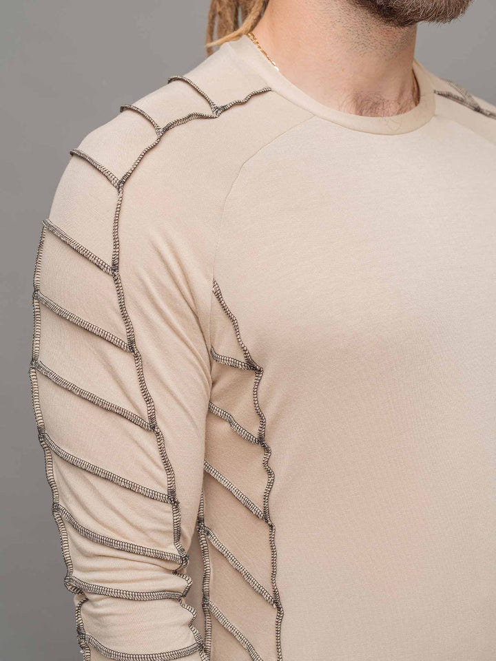 Raider dystopian avant garde men's longline t-shirt in sand with black contrast stitch and thumbholes for a distressed look - focus on raglan sleeve