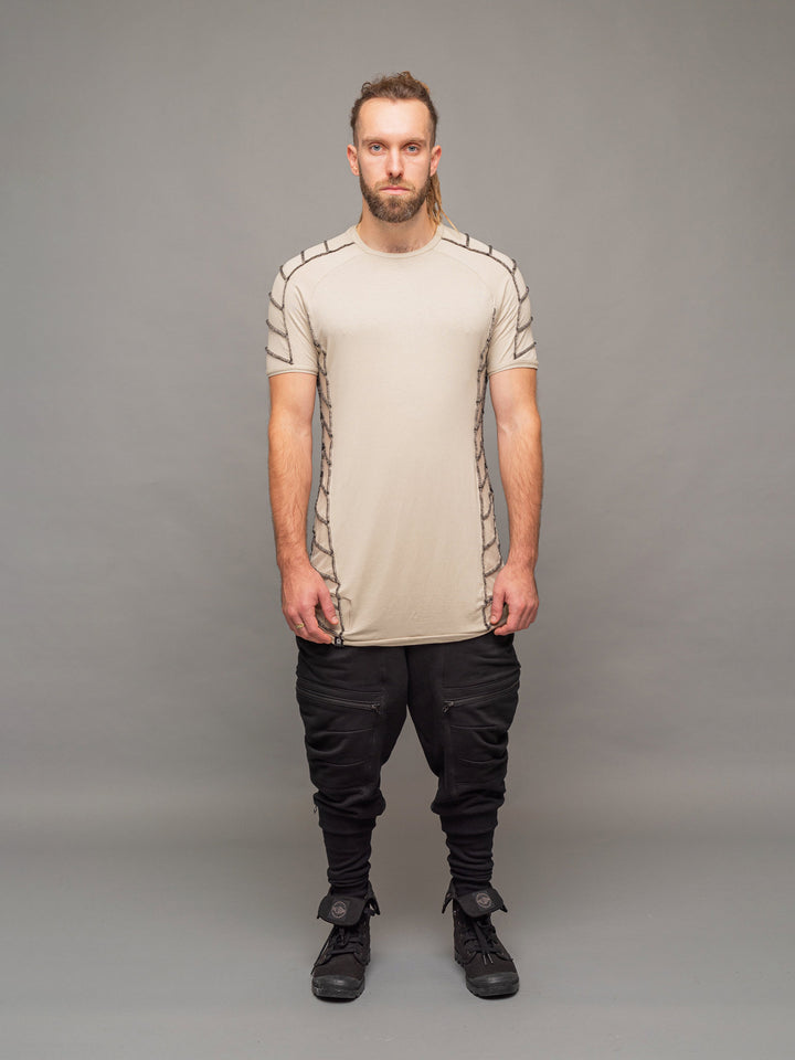 full body view of the Raider short sleeve t-shirt in sand with black stitching, paired with the Nomadix joggers