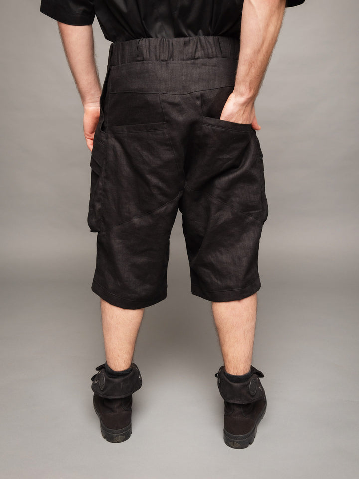 Zyrex drop crotch knee length shorts in sand with 8 pocket design - Back view with hand in pocket
