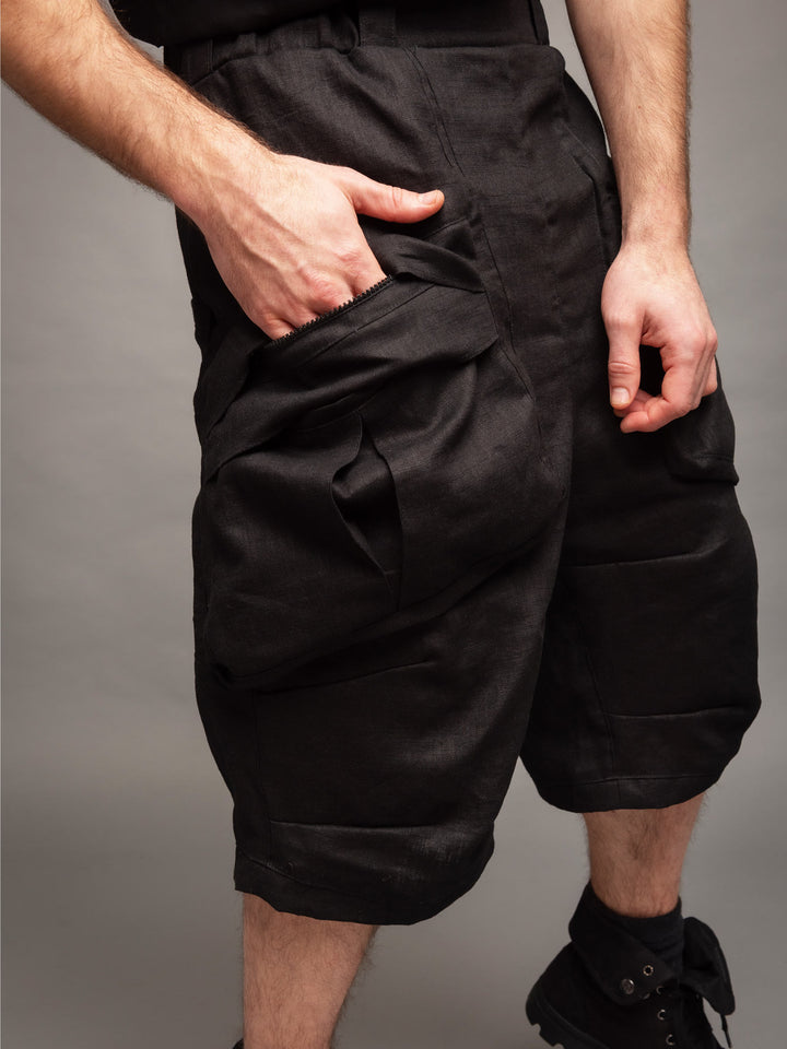 Zyrex drop crotch knee length shorts in sand with 8 pocket design - Front side view with hand in pocket