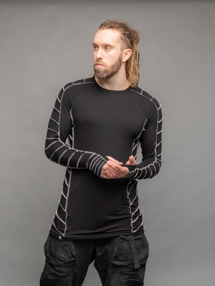 Raider dystopian longline tshirt in black with thumbholes and contrast overlock stitch details in grey - pose in movement